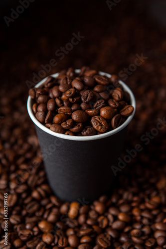 Take away black coffee cup with roasted coffee beans. Space for application logo