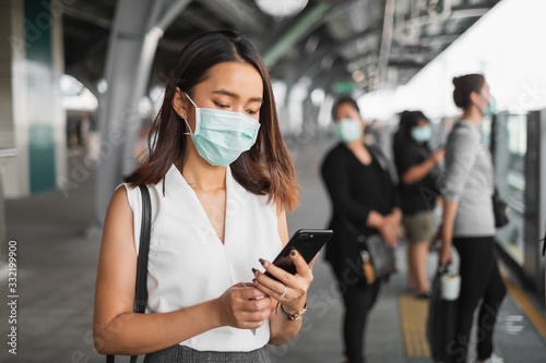 Coronavirus(Covid-19) concept, Asian woman wearing protective face mask to protect infection from coronavirus covid-19 standing at sky train and crowd people