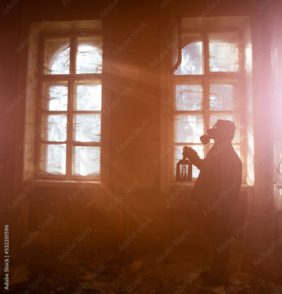 Dramatic portrait of a woman wearing a gas mask in a ruined building. Dramatic portrait of a woman wearing a gas mask in a ruined building.