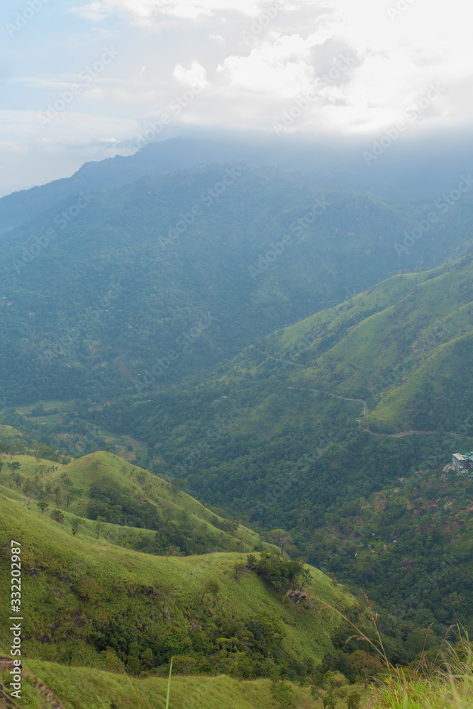 Mountain landscape, green slopes. Beauty of mountains. Little Adam peak, mountain in the fog view from the jungle Mountain landscape, green slopes. Beauty of mountains. Little Adam peak, mountain in the fog view from the jungle