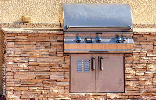 An outdoor kitchen with a grill mounted in a stone counter.
