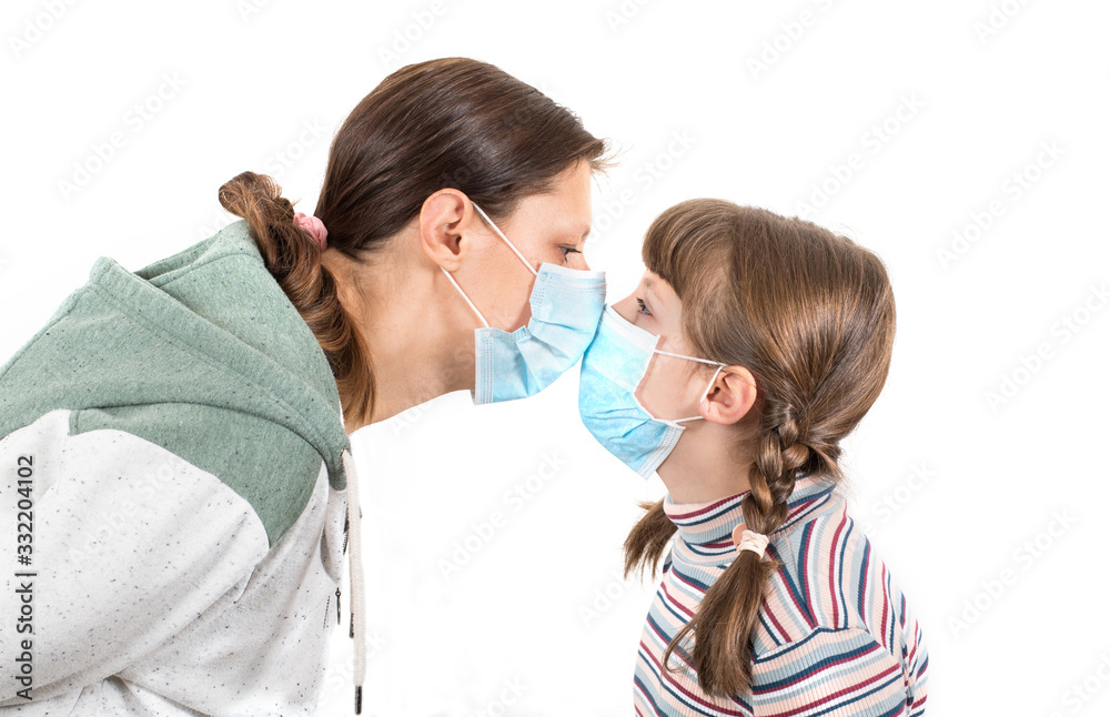 mother and daughter wearing a virus face mask kissing concept for corona virus