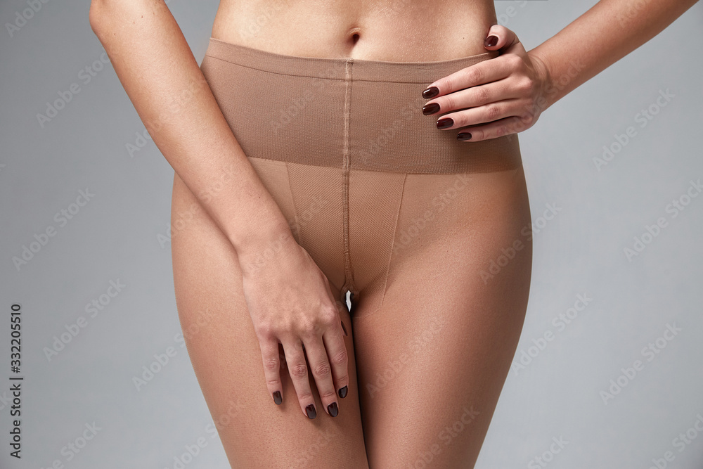 Foto de Part of woman body perfect shape hips legs skin tan wear stockings,  nylons, pantyhose lingerie hosiery hose studio shot on white background. do  Stock