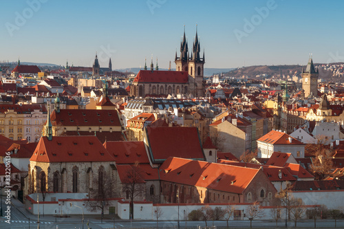 Overall view of Old Town of Prague shortly after sunrise, sunny spring day with blue sky. St Agnes convent in foreground, rooftop and towers of Church of Our Lady before Tyn in middle.