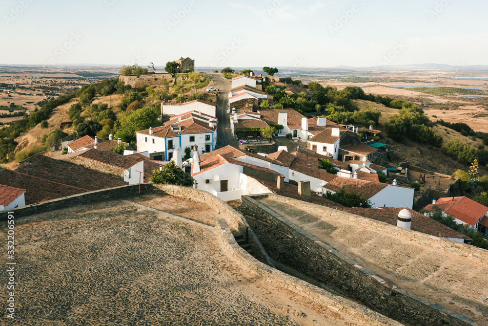 Monsaraz village, near the Alqueva dam, in Portugal, at sunset,with the typical houses from Alentejo on foreground and the wheat fields on background