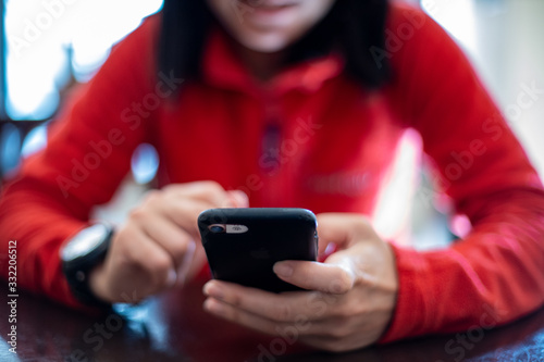 woman in red looking in the cell phone