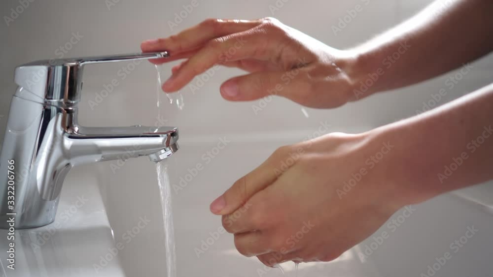 Persona lavando las manos para desinfectar y prevenir la infección de corona virus con agua y jabón en el baño cámara lenta HD