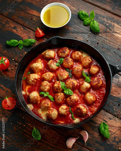Lean Turkey breast meat balls in cheesy tomato passata sauce served in cast iron frying pan skillet