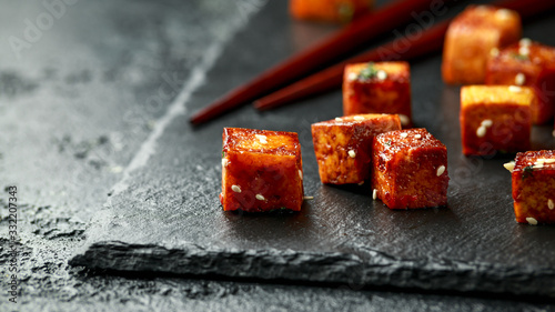 Fried Tofu with chopstick and sesame seeds on rustic stone board