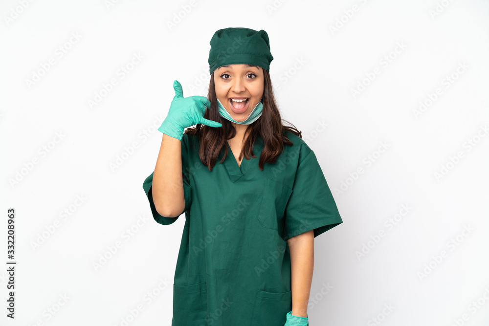 Surgeon woman in green uniform isolated on white background making phone gesture. Call me back sign Surgeon woman in green uniform isolated on white background making phone gesture. Call me back sign