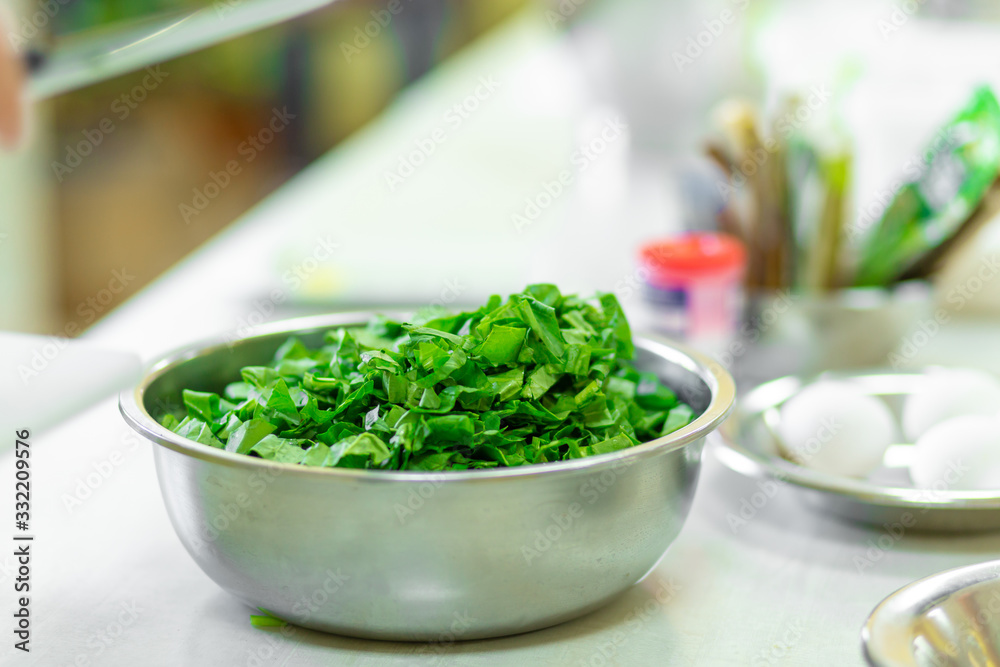 Cook in the kitchen cuts greens close up Cook in the kitchen cuts greens close up