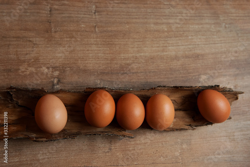 five eggs lie in the bark on a wooden surface