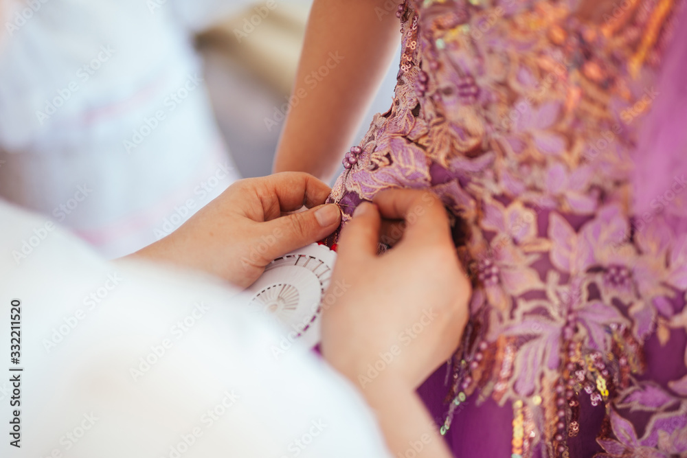 Dressmaker fixes dress sizes with a needle Dressmaker fixes dress sizes with a needle