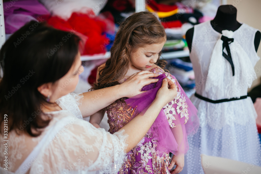 Seamstress fashion designer takes a new order in his studio. Makes dress measurements