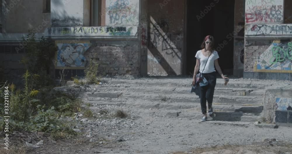 Female tourist walking near an abandoned house on sunny day in summer. Female tourist walking near an abandoned house on sunny day in summer.