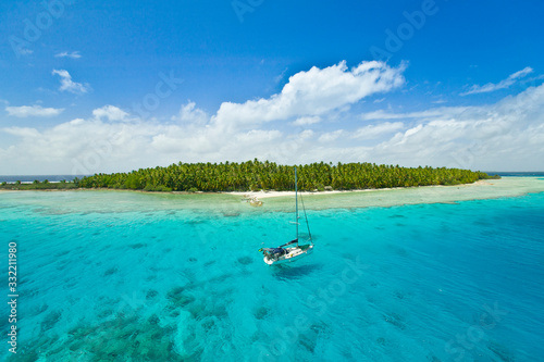 Sailing yacht anchoring in the shallow waters of suwarrow atoll, cook islands, polynesia, pacific ocean © Uwe