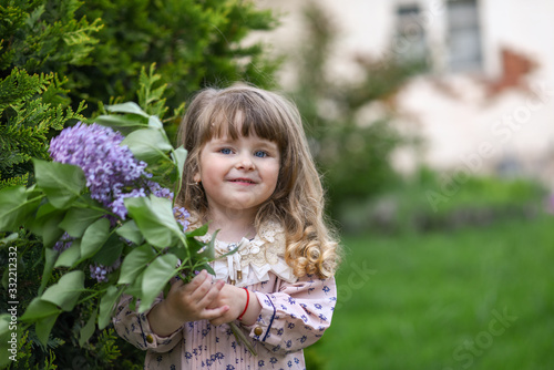 little girl with a bouquet of wild flowers. girl with flowers. portrait of a girl in garden. mothers Day
