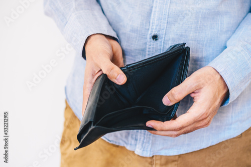 Man holding an empty wallet - economic crisis concept.