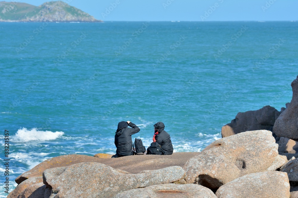 people sitted on the rock in Brittany. France