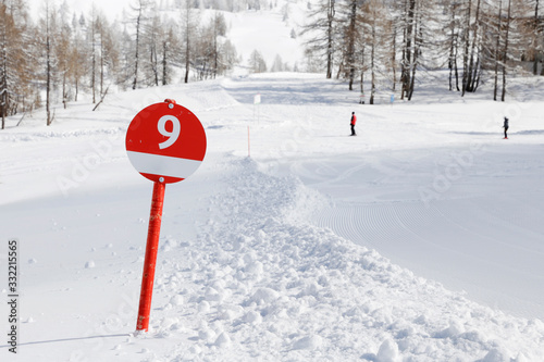 A red ski slope with number 9. Ski piste in the alp mountains.  photo