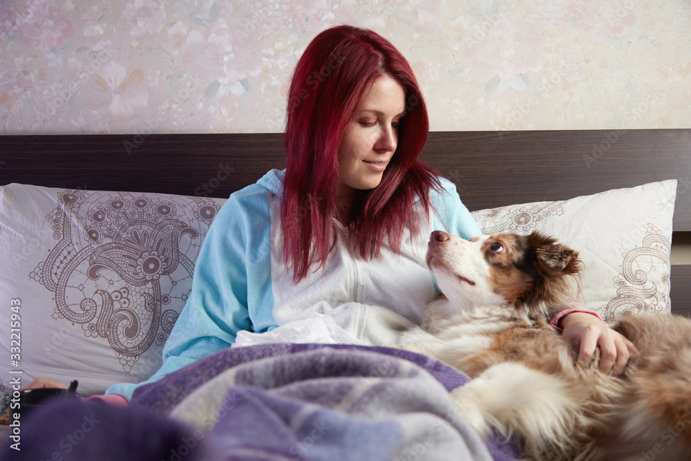 Sick woman in bed with dog looking at each other Sick woman in bed with dog looking at each other