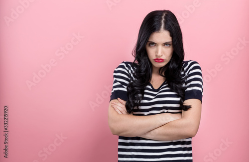 Angry young woman on a pink background