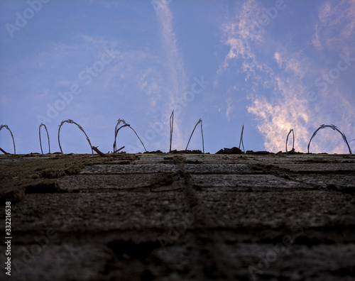 high block wall with spikes like a jail with cute purple sunset photo