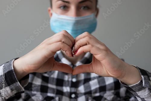 Girl with medical mask to protect her from virus. Coronavirus pandemic. Woman with mask standing . People being hospitalized, diagnosed, often put in carantine (isolation) to stop spreading Corona. photo