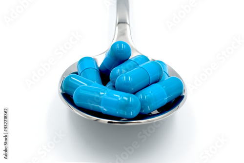 Spoon of blue viagra pills, blue capsules