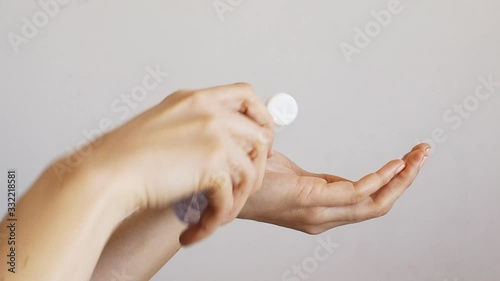 Female hands cleaning washing with sanitizer gel over bright gray background