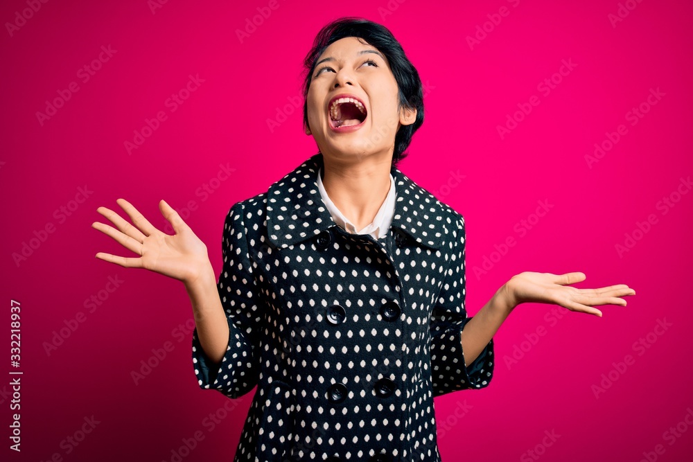 Young beautiful asian girl wearing casual jacket standing over isolated pink background celebrating crazy and amazed for success with arms raised and open eyes screaming excited. Winner concept Young beautiful asian girl wearing casual jacket standing over isolated pink background celebrating crazy and amazed for success with arms raised and open eyes screaming excited. Winner concept
