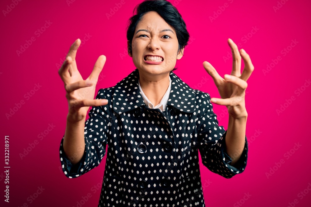 Young beautiful asian girl wearing casual jacket standing over isolated pink background Shouting frustrated with rage, hands trying to strangle, yelling mad Young beautiful asian girl wearing casual jacket standing over isolated pink background Shouting frustrated with rage, hands trying to strangle, yelling mad