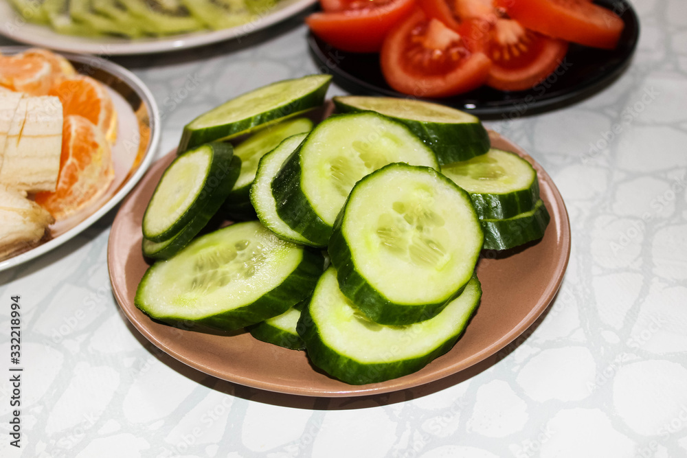 Sliced cucumbers in rings on a plate. Slicing fruit and vegetables on the table. Sliced cucumbers in rings on a plate. Slicing fruit and vegetables on the table.