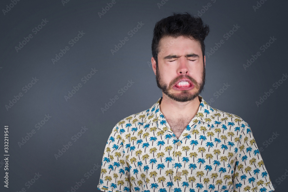 Negative human expressions and attitude. Angry dissatisfied male has disgusting expression as sees something not appealing, frowns face, isolated over white  background. Distaste and dislike