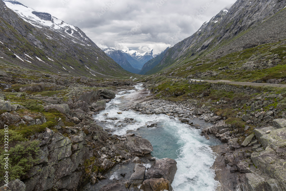 river that runs between high mountains of Norway during the summer