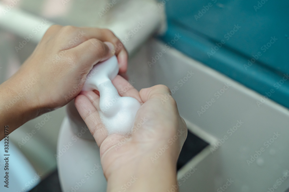 A hand soap with pumping lotion from bottle. Hygiene girl hands concept. 