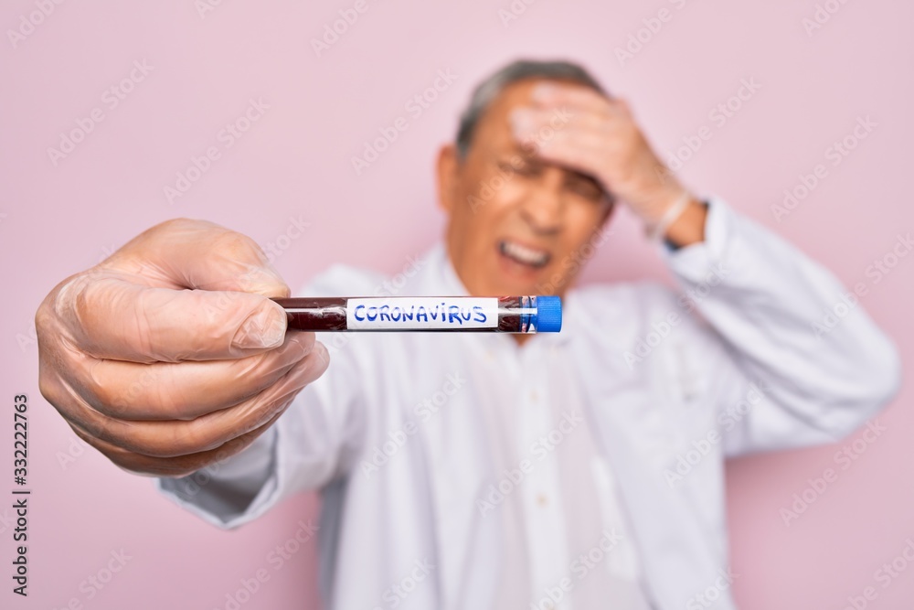 Senior handsome hoary man holding coronavirus tube test over isolated pink background stressed with hand on head, shocked with shame and surprise face, angry and frustrated. Fear and upset Senior handsome hoary man holding coronavirus tube test over isolated pink background stressed with hand on head, shocked with shame and surprise face, angry and frustrated. Fear and upset