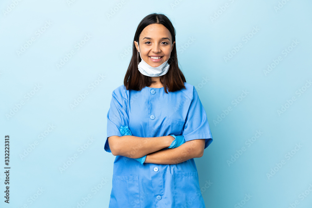 Surgeon woman over isolated blue background keeping the arms crossed in frontal position Surgeon woman over isolated blue background keeping the arms crossed in frontal position