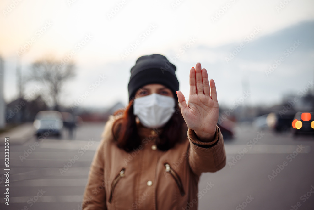 Coronavirus and Air pollution pm2.5 concept. Young woman wearing mask to protect from covid-19 and shows stop hand gesture for stop corona virus outbreak. Wuhan virus and epidemic symptoms.