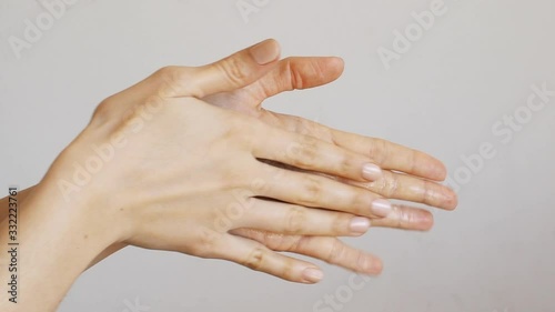 Female hands cleaning washing with sanitizer gel over bright gray background