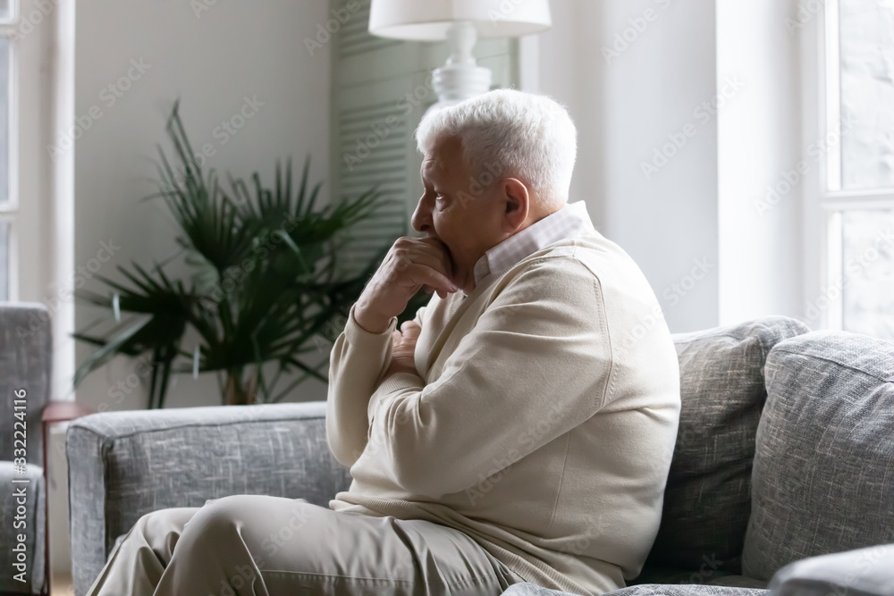 Grey haired old man sit on couch in living room alone, lost in sad pessimistic thoughts related to senile disease, mental disorder memory loss or dementia. Life troubles and lonely 80s person concept Grey haired old man sit on couch in living room alone, lost in sad pessimistic thoughts related to senile disease, mental disorder memory loss or dementia. Life troubles and lonely 80s person concept