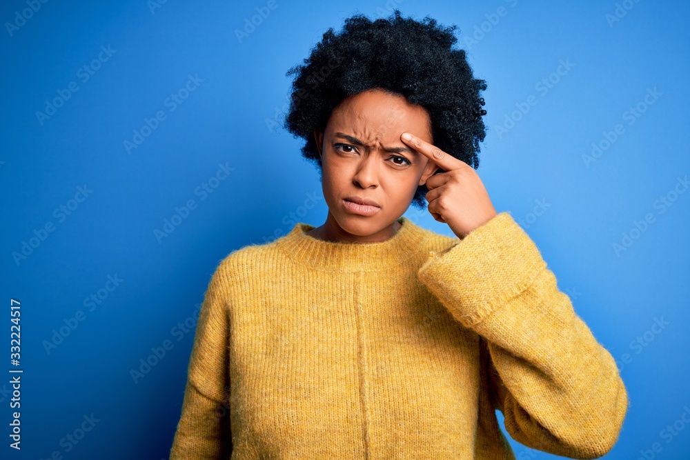 Young beautiful African American afro woman with curly hair wearing yellow casual sweater pointing unhappy to pimple on forehead, ugly infection of blackhead. Acne and skin problem Young beautiful African American afro woman with curly hair wearing yellow casual sweater pointing unhappy to pimple on forehead, ugly infection of blackhead. Acne and skin problem