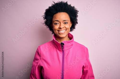Young African American afro sportswoman with curly hair wearing sportswear doin sport with a happy and cool smile on face. Lucky person.