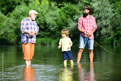 Father, son and grandfather on fishing trip. Happy weekend concept. Father, son and grandfather relaxing together.