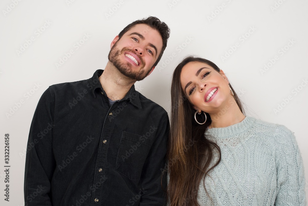 Beautiful smiling brunette female with broad smile, shows white teeth, wears casual t shirt, stands over gray studio wall rejoices having day off. Woman standing indoors. Beautiful smiling brunette female with broad smile, shows white teeth, wears casual t shirt, stands over gray studio wall rejoices having day off. Woman standing indoors.