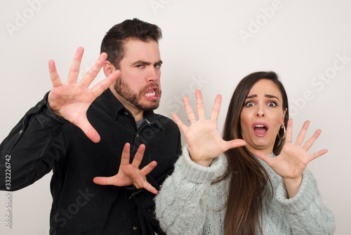 Dissatisfied female model frowns face, has disgusting expression, shows tongue, expresses non compliance, irritated with somebody, rejects do something. People and negative facial expressions photo