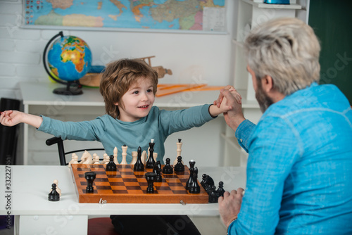 At home. Dad with his child son are playing Chess. Chess strategy. Back to school and Education concept.