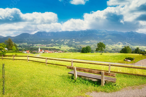 Bank in Landschaft mit Wiese und Bergen
