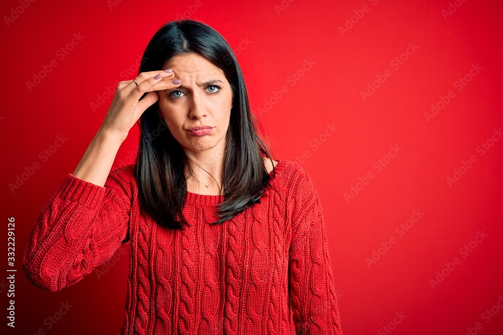 Young brunette woman with blue eyes wearing casual sweater over isolated red background worried and stressed about a problem with hand on forehead, nervous and anxious for crisis Young brunette woman with blue eyes wearing casual sweater over isolated red background worried and stressed about a problem with hand on forehead, nervous and anxious for crisis