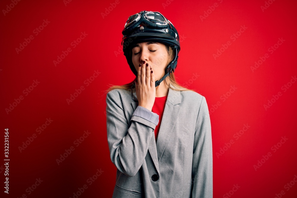 Young beautiful blonde motorcyclist woman wearing motorcycle helmet over red background bored yawning tired covering mouth with hand. Restless and sleepiness. Young beautiful blonde motorcyclist woman wearing motorcycle helmet over red background bored yawning tired covering mouth with hand. Restless and sleepiness.